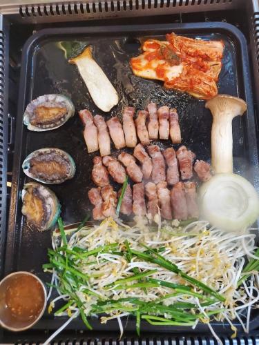 a tray of food with sausage and vegetables on it at The Stay Century Hotel in Jeju