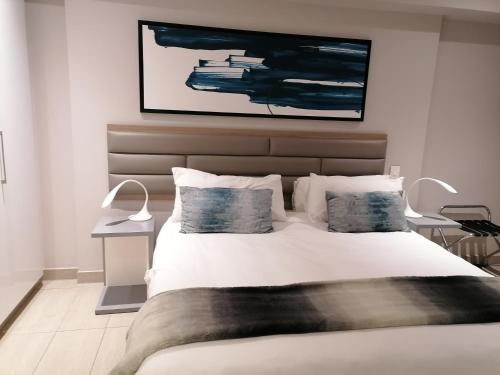 1 dormitorio con 1 cama blanca grande y 2 almohadas en Pearls of Umhlanga Apts, en Durban