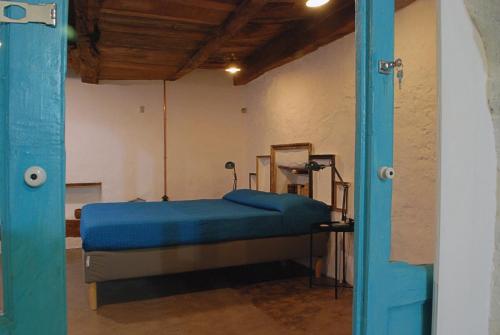 a bedroom with a bed in a room with a blue door at B&B Donna Livia in Cantalupo nel Sannio