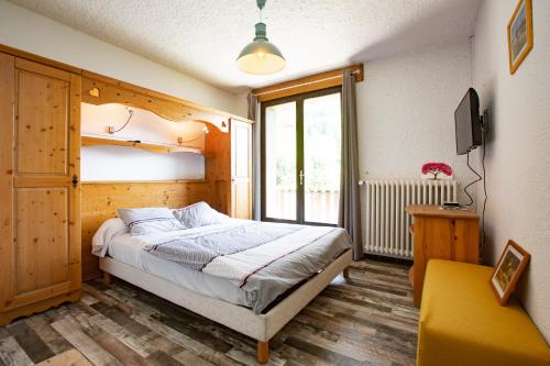 une chambre avec un lit et une grande fenêtre dans l'établissement Chez Passoud, à Vaujany