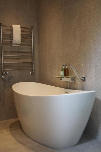 a large white bath tub in a bathroom at The Merchant's Yard in Tideswell