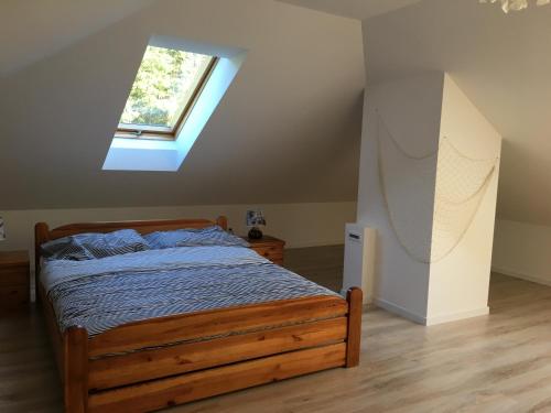 a bedroom with a wooden bed with a window at Kopalnia Wspomnień in Kopalino