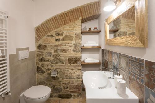 baño con lavabo y pared de piedra en Podere Vecchia Commenda, en Massa Marittima