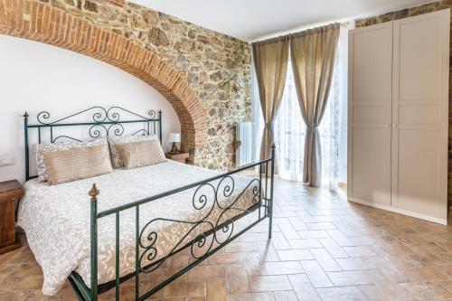 a bedroom with a bed and a brick wall at Podere Vecchia Commenda in Massa Marittima