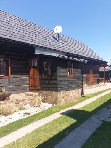 Cabaña de madera con fachada de piedra y porche en Drevenica Raj en Bystrička