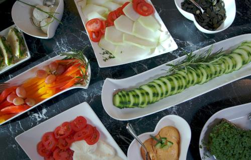 a table topped with plates of food with vegetables at Pension Traube in Uderns