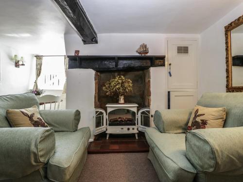 a living room with two couches and a fireplace at Small Piece in Minehead