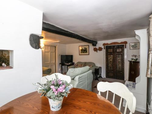 a living room with a table with flowers on it at Small Piece in Minehead