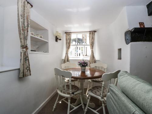 a dining room with a table and chairs and a window at Small Piece in Minehead