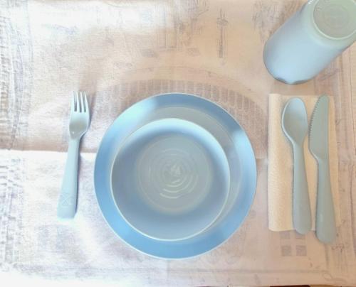 a table with a blue plate and fork and knife at Sea House Rimini Fiera in Rimini