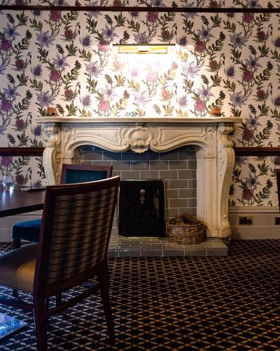 a living room with a fireplace and a chair at Woodlands Hotel, BW Signature Collection in Dundee