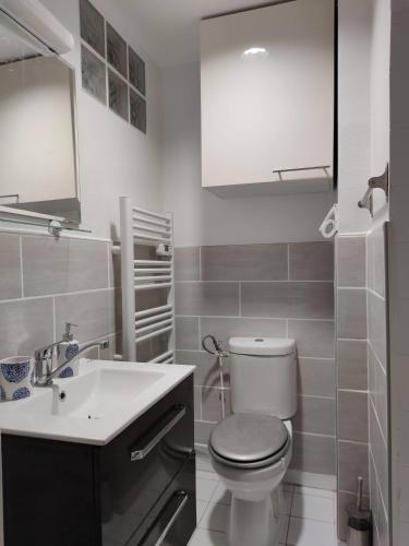 a white bathroom with a toilet and a sink at Modern 1 bedroom apartment near the metro. in Ivry-sur-Seine