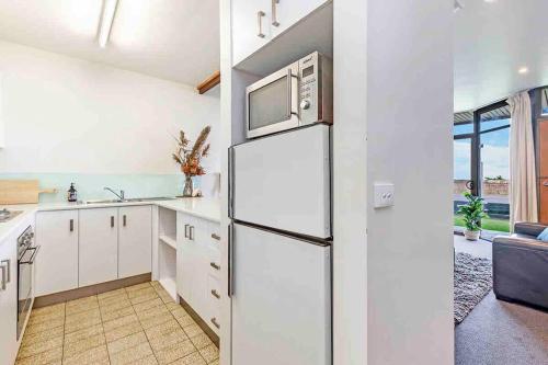 a kitchen with a refrigerator and a microwave at Oceanscape ~ OCEAN VIEWS Uninterrupted in Portland