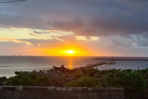 a sunset over the ocean with a boat in the water at Oceanscape ~ OCEAN VIEWS Uninterrupted in Portland