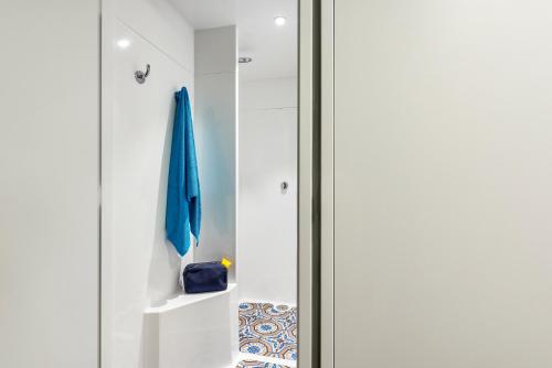 a glass door leading into a bathroom with a blue umbrella at hotelF1 La Rochelle Angoulins "Rénové" in Angoulins