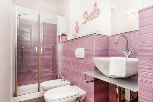 a pink bathroom with a sink and a toilet at Villino Caterina House: big terrace seaview in Riomaggiore