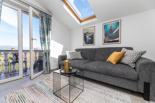 a living room with a couch and a view of the ocean at Pansion Tina in Šilo
