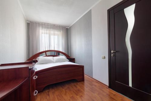 Schlafzimmer mit einem Bett und einer Holztür in der Unterkunft New apartment Lux in Most City area in Dnipro