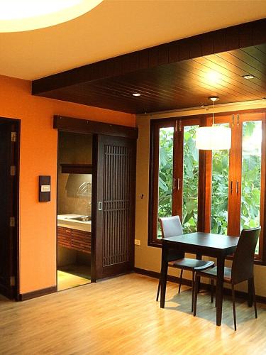 a dining room with a black table and chairs at Burapa Boutique in Chiang Mai