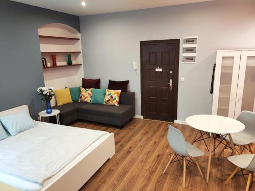 a bedroom with a bed and a couch and a table at Centrum Apartament Old Town in Świdnica