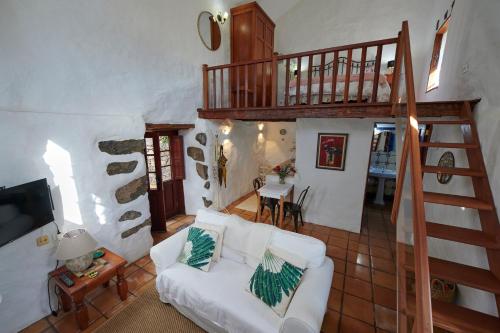 a living room with a white couch and a staircase at Casita Pedro González in Erese