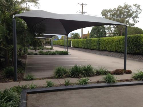 a black umbrella in a park with plants at Francis Phillip Motor Inn and The Lodge in Singleton