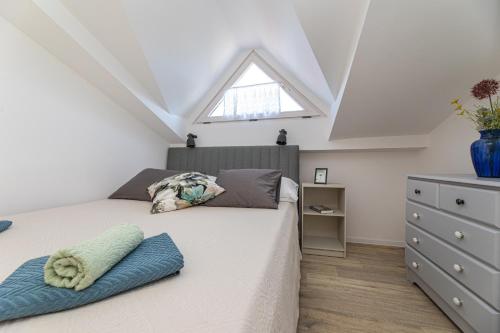 a attic bedroom with a bed and a window at Pansion Tina in Šilo