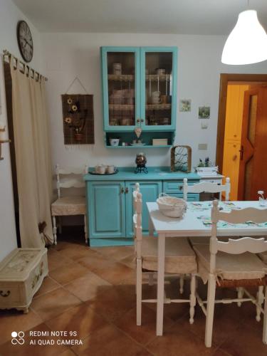 a kitchen with blue cabinets and a table and chairs at La Bouganville e Il Gelsomino in Pietrasanta