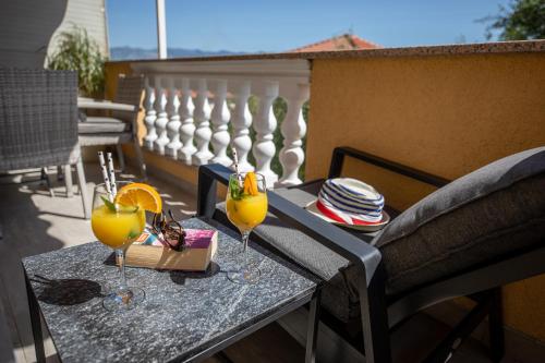a table on a balcony with two glasses of orange juice at Pansion Tina in Šilo