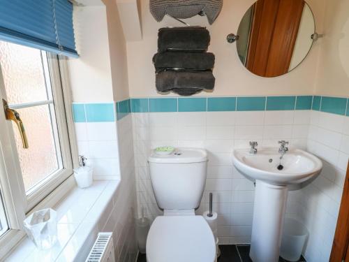 a bathroom with a toilet and a sink at Chestnuts Barn in Belper