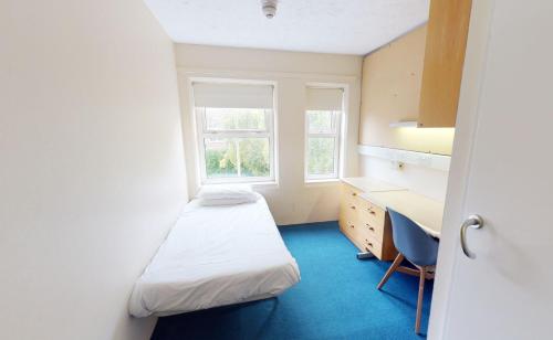 a room with two beds and a desk and a window at Phoenix Halls in Brighton & Hove