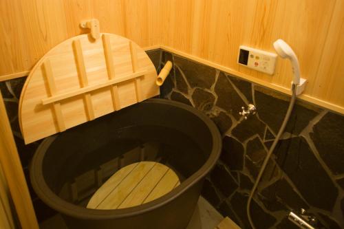 a toilet with a wooden seat in a bathroom at Demizu Machiya Machiya Inn in Kyoto