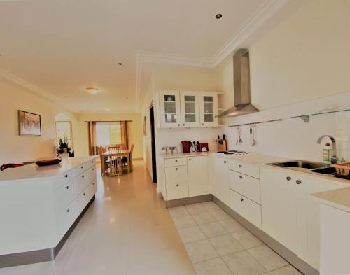 a large white kitchen with white cabinets and a table at Kololi Beach Resort in Kololi