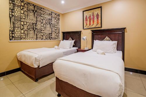 a hotel room with two beds and a painting on the wall at The Sails G6-07 on Timeball Boulevard in Durban