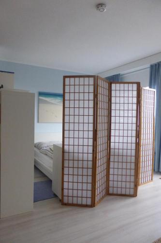 a room with a bed and a pair of sliding doors at Ostsee-Apartment "Weite Welt" in Kiel