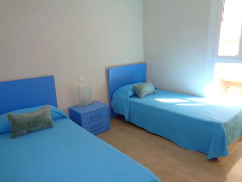 カルプにあるEdificio Porto Azulのベッドルーム1室(青いベッド2台、窓付)