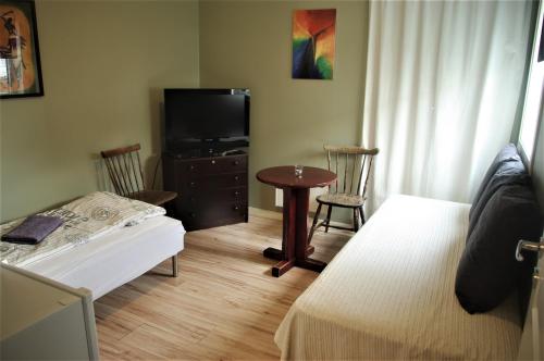 a bedroom with a bed and a tv and a table at Strandheimen Guesthouse in Melhus