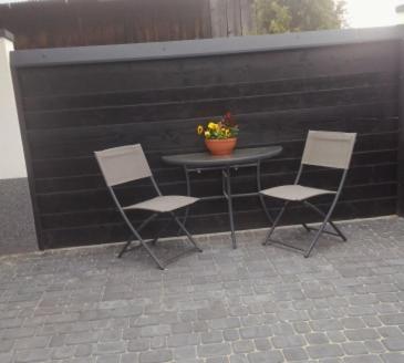 three chairs and a table with a plant on a patio at U Beaty, niezależne mieszkania do wynajęcia in Ochotnica Górna