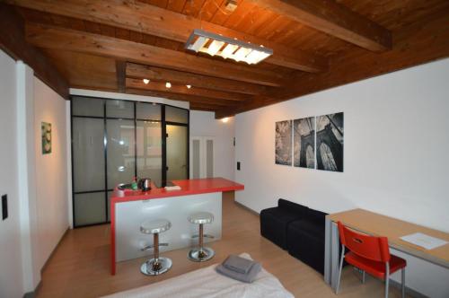 una cucina e un soggiorno con piano di lavoro rosso di GuestHouse University by LR - self check in a Lugano