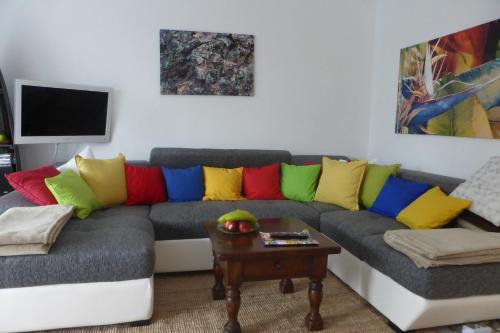 ein Wohnzimmer mit einem Sofa und bunten Kissen in der Unterkunft Ostsee-Apartment "Weite Welt" in Kiel