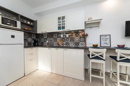 a kitchen with white cabinets and a counter at Pansion Tina in Šilo