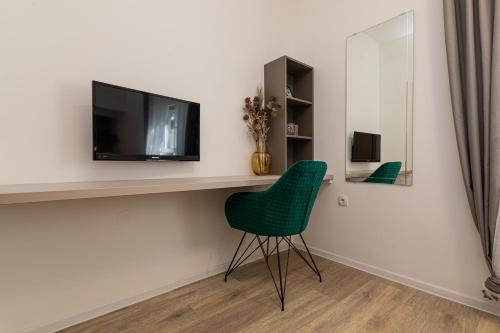 a living room with a green chair and a tv at Pansion Tina in Šilo