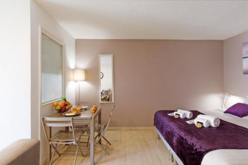 Habitación de hotel con cama, mesa y cama en Antares S YourHostHelper, en Cannes