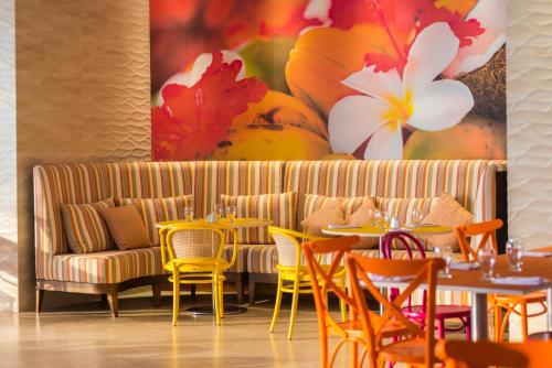 a restaurant with tables and chairs and a couch at Radisson Cartagena Ocean Pavillion Hotel in Cartagena de Indias