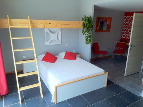 a bedroom with a bunk bed with red pillows and a ladder at Pousada B&B Le Gourmet in São Pedro