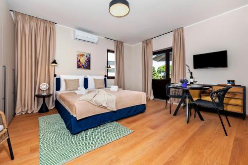 a bedroom with a bed and a desk and a television at Sunset Residence Rovinj in Rovinj
