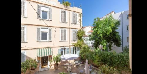 Blick auf ein Gebäude mit einem Baum davor in der Unterkunft Appartement palais plages in Cannes