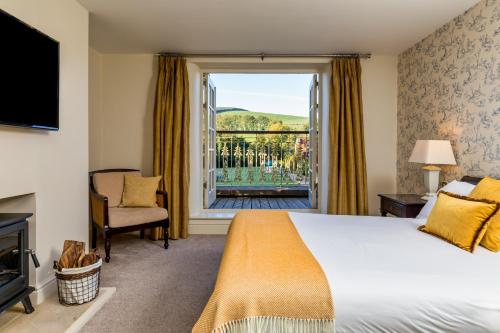 um quarto de hotel com uma cama e uma grande janela em BrookLodge & Macreddin Village em Aughrim