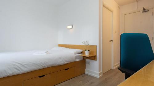 1 dormitorio con 1 cama y 1 silla azul en Dromroe Village University of Limerick en Limerick