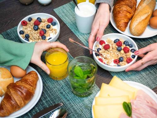a table topped with plates of breakfast foods and drinks at ibis Styles Delft City Centre in Delft